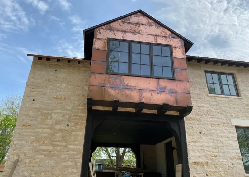 Copper metal panel facade on a stone building for Roof Repair in Lake Goodwin